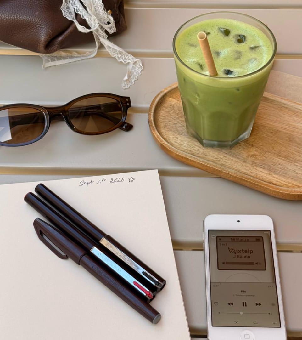 Matcha latte glacé, carnet, stylos et lunettes de soleil